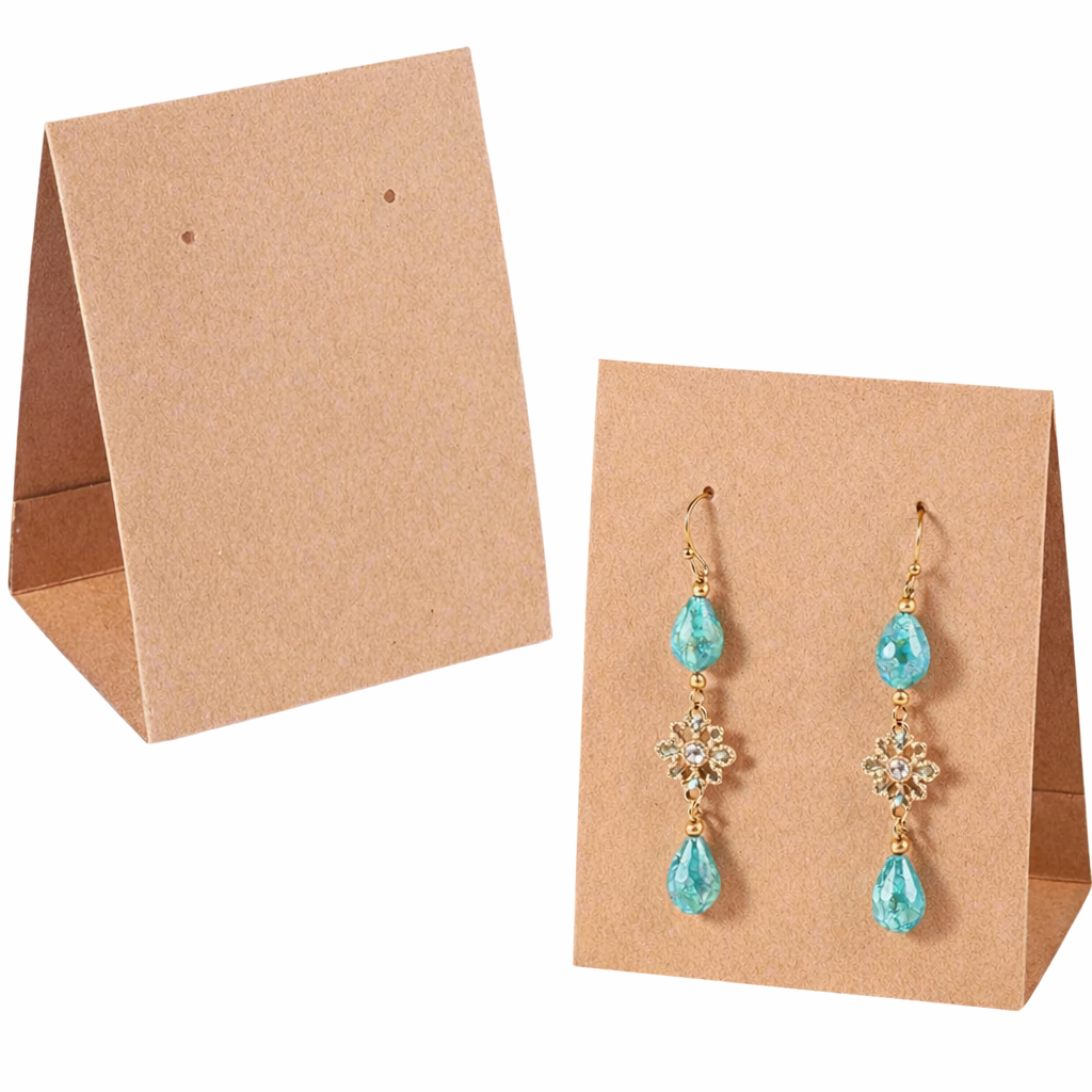 A pair of gold drop earrings with light blue teardrop gemstones and clear crystal details, displayed on a brown kraft paper stand against a white background.